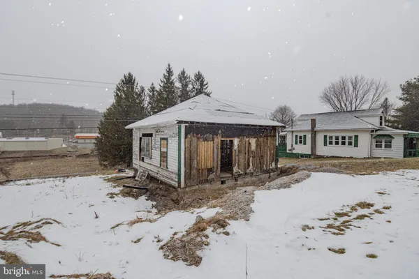 a front view of a house with a yard covered in snow