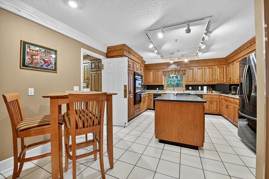 167 Whispering Pne Lane Cherry Log, GA 30522 - Photo 29 of 87 a kitchen with stainless steel appliances kitchen island granite countertop a refrigerator a stove a sink with a dining table and chairs