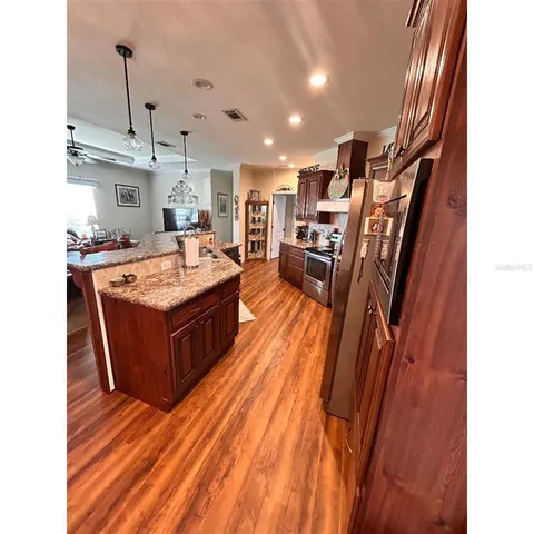 a large living room with stainless steel appliances granite countertop furniture and a fireplace