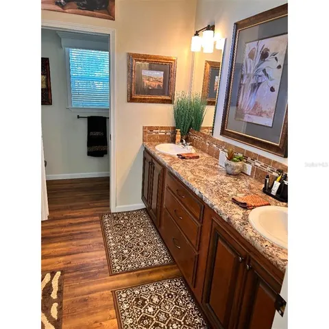 a bathroom with granite countertop a sink and a stove with wooden floor
