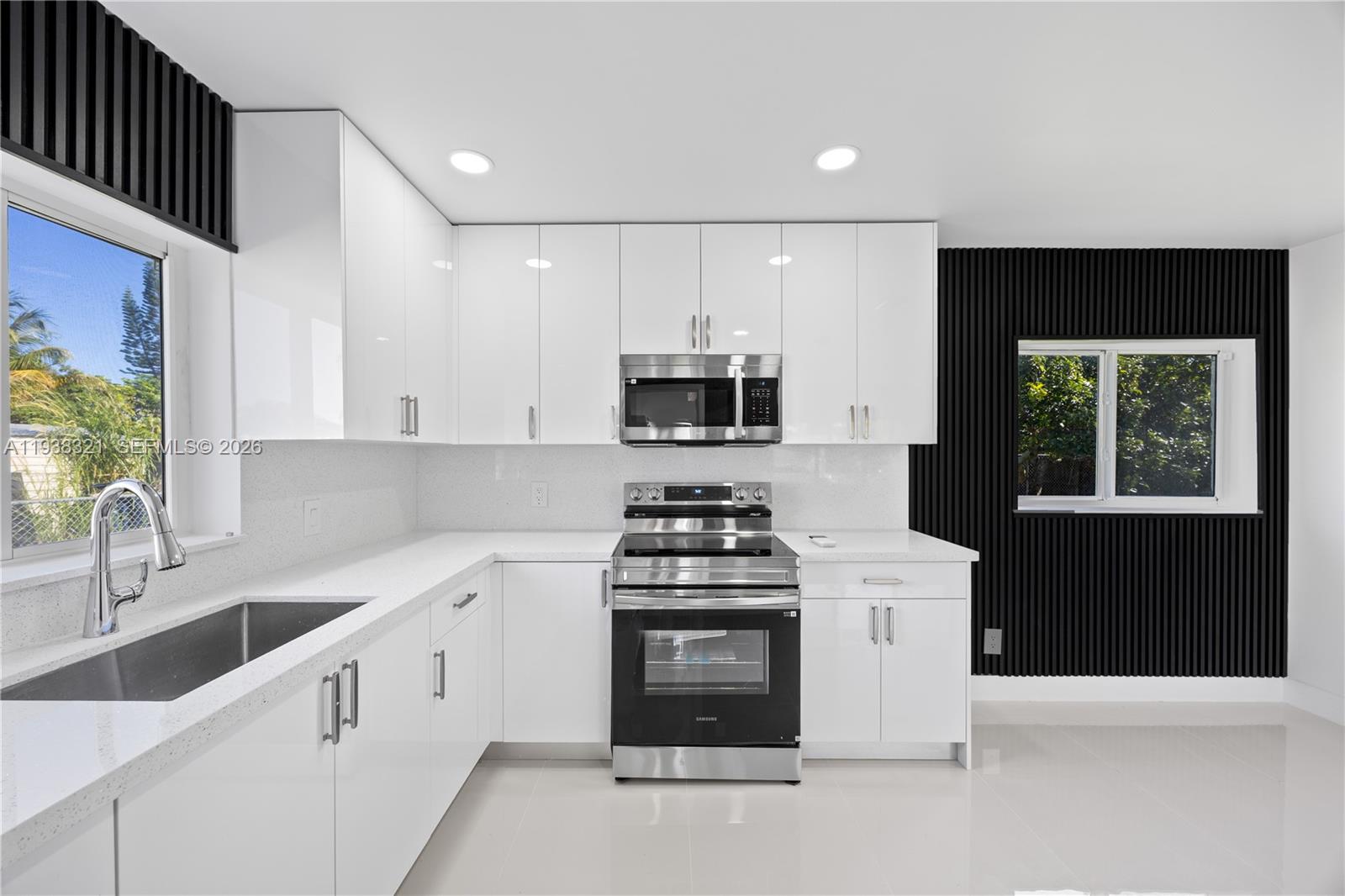 22503 Southwest 113th Place Miami, FL 33170 - Photo 19 of 35 a kitchen with granite countertop white cabinets and black stainless steel appliances