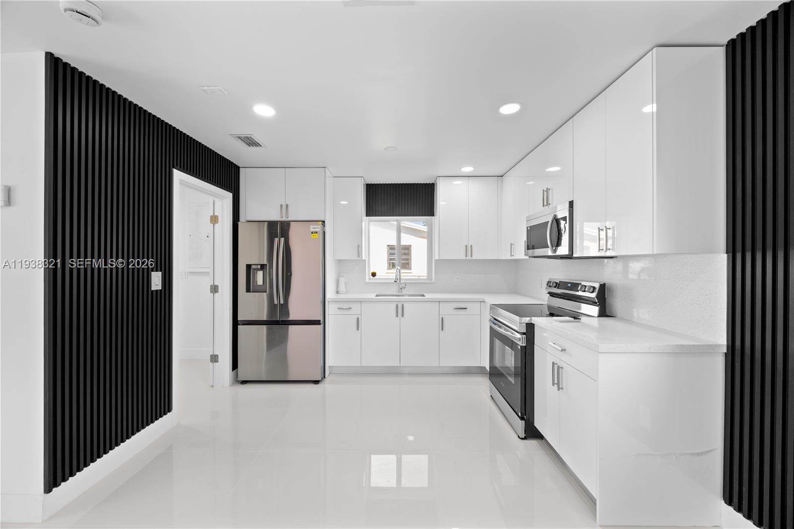 22503 Southwest 113th Place Miami, FL 33170 - Photo 2 of 35 a kitchen with a refrigerator a sink and cabinets