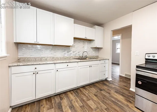 a kitchen with granite countertop white cabinets and white appliances