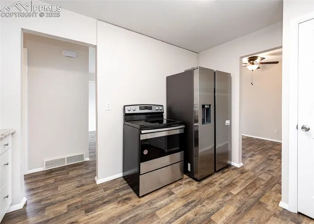 a kitchen with a refrigerator and a stove top oven