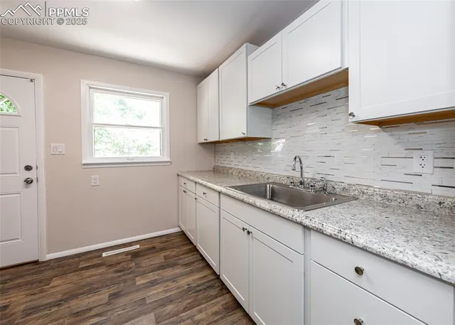 a kitchen with granite countertop wooden cabinets a sink and dishwasher