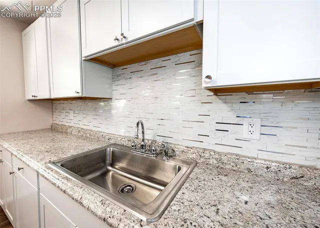 a kitchen with granite countertop a sink and a stove