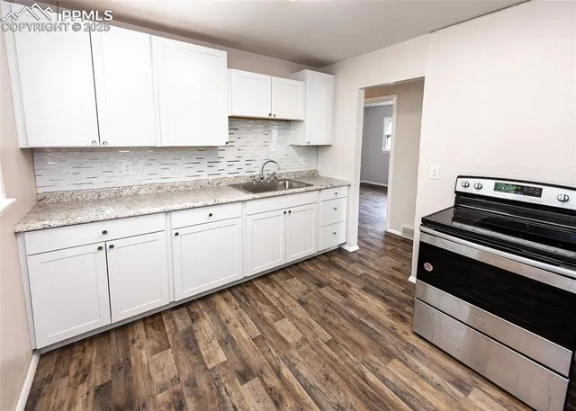 a kitchen with granite countertop white cabinets and white appliances