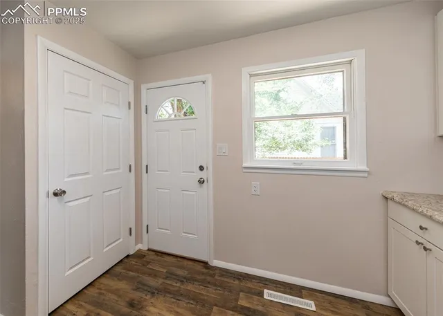 a view of an empty room with closet and a window