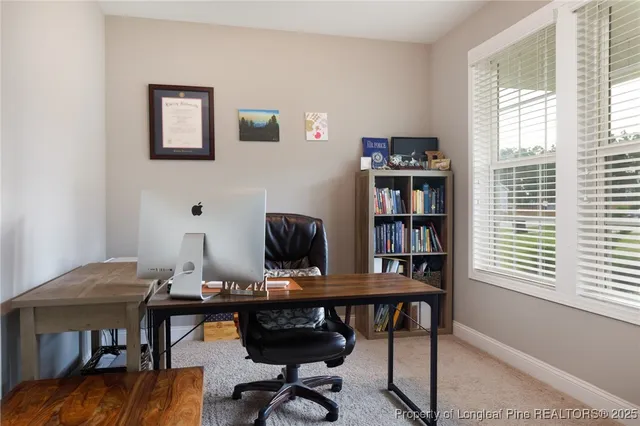 a view of a workspace with furniture and a window