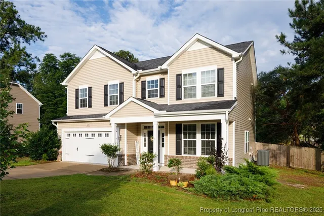 a view of a white house with a yard and plants