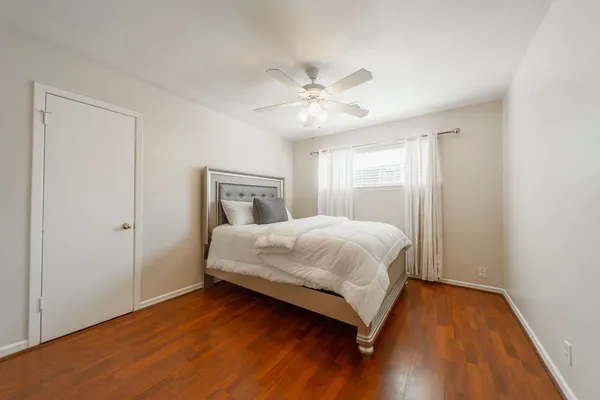 a bedroom with a bed and wooden floor