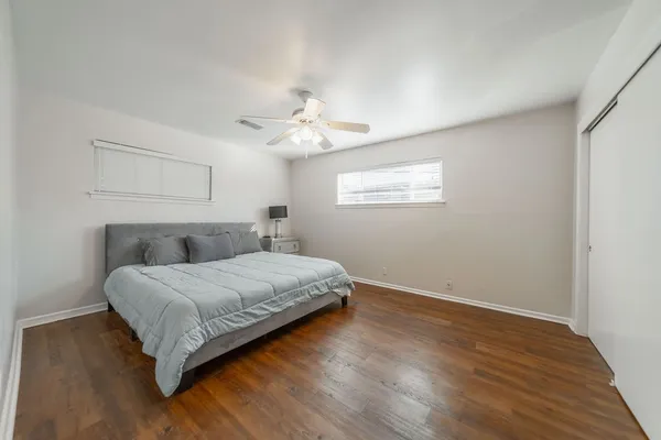 a spacious bedroom with a bed and a chandelier