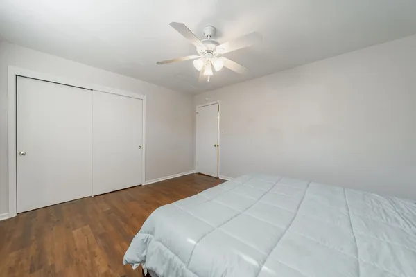an empty room with closet and ceiling fan