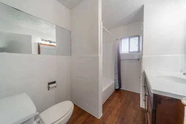 a bathroom with a sink a toilet a window and vanity