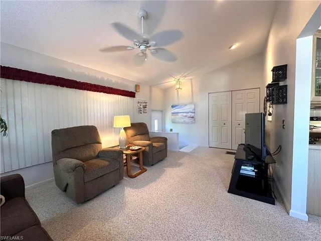 a living room with furniture and a ceiling fan