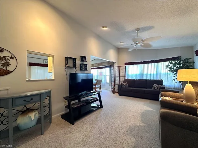a living room with furniture a ceiling fan and a window