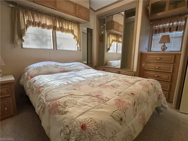 a large bed in a bedroom next to a window