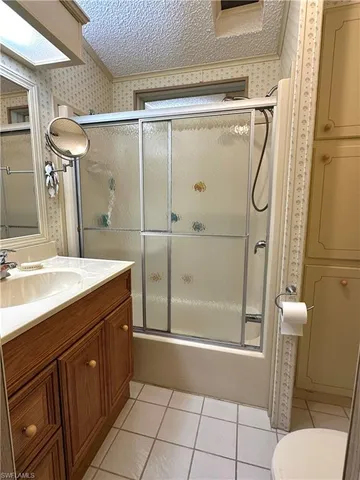 a bathroom with a shower sink mirror and toilet