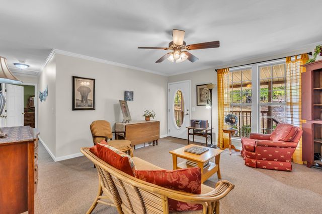 a living room with furniture and a ceiling fan