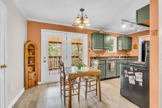 a living room with dining table and a chandelier