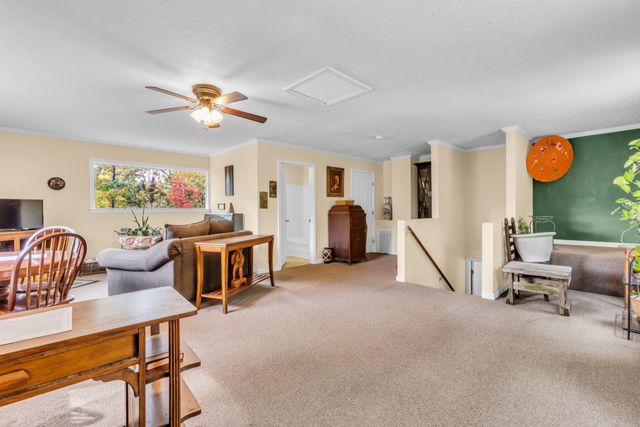 a living room with furniture a flat screen tv and a window