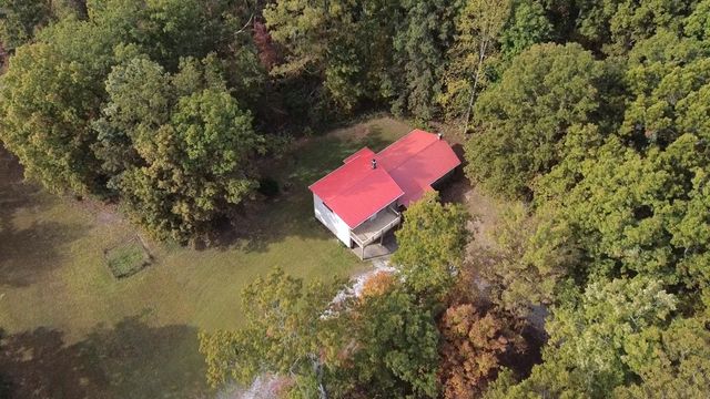 an aerial view of a house with a yard and swimming pool