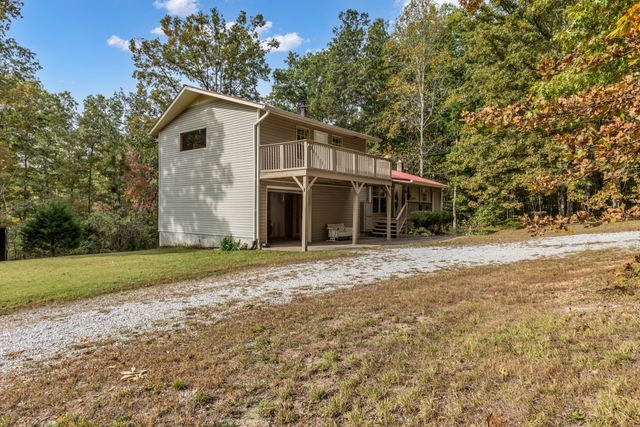 a view of a yard in front of a house with large trees