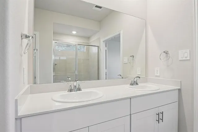 a bathroom with a double vanity sink and mirror