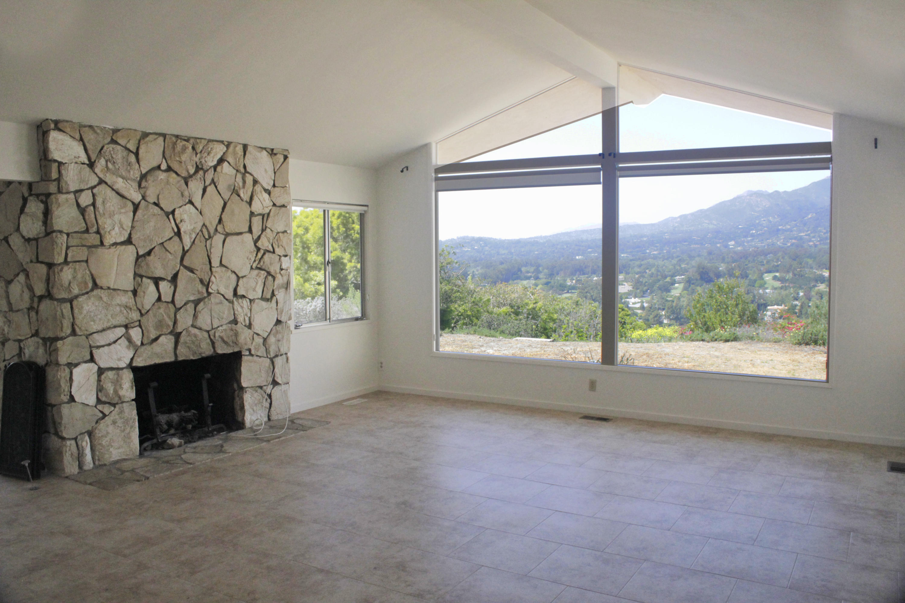 371 Ortega Ridge Road Santa Barbara, CA 93108 - Photo 4 of 7 an empty room with windows and fireplace