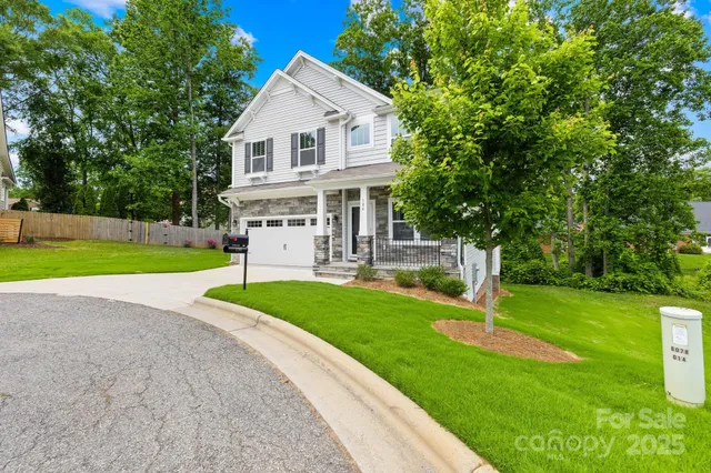 a front view of a house with a yard and trees