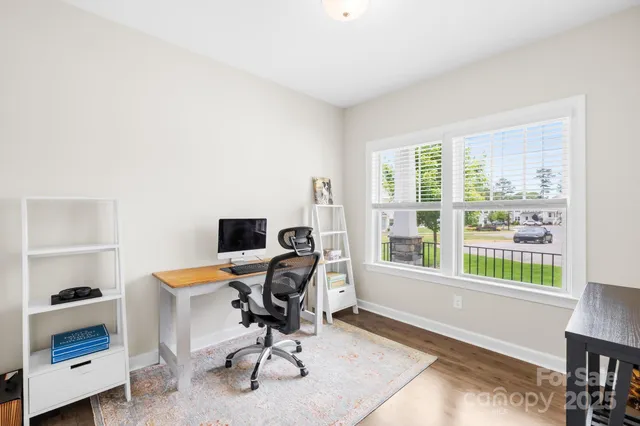 a view of a workspace with furniture and a window