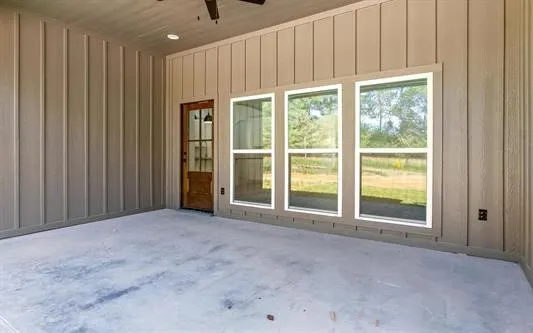 a view of an empty room with a window and doors