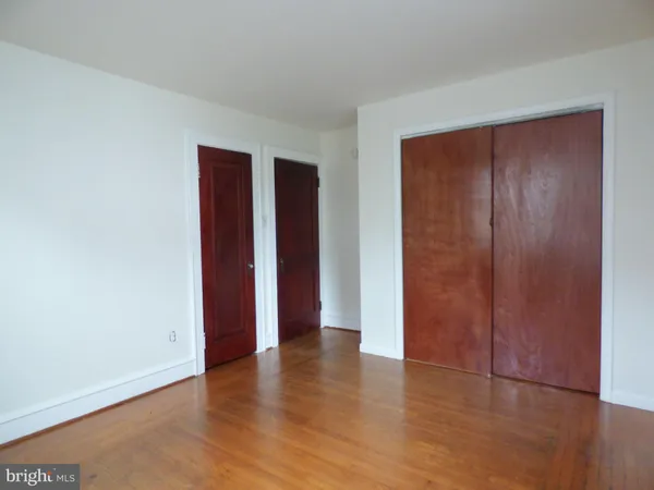 an empty room with wooden floor and closet