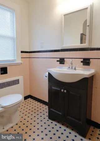 a bathroom with a sink a toilet a mirror and shower