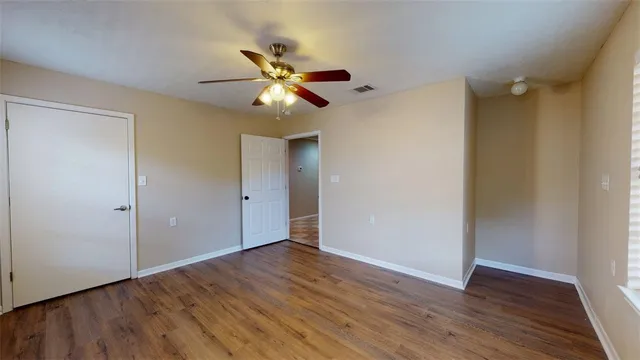 a view of an empty room with wooden floor