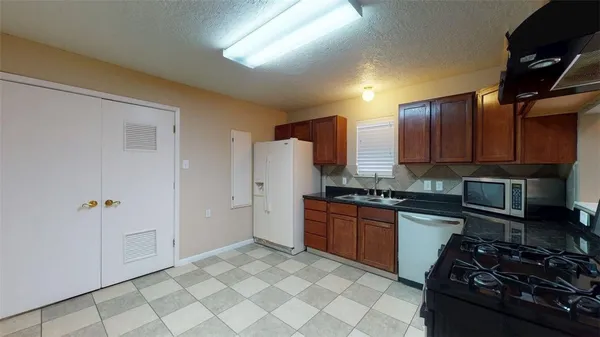 a kitchen with stainless steel appliances granite countertop a stove refrigerator and cabinets