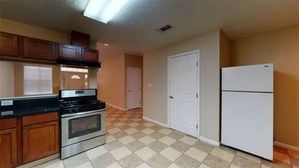 a kitchen with stainless steel appliances granite countertop a refrigerator and a stove top oven