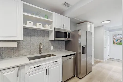 a kitchen with a sink stainless steel appliances and cabinets