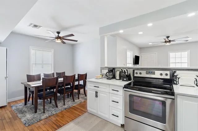 a kitchen with a stove cabinets and dining table