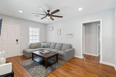 a living room with furniture and a wooden floor
