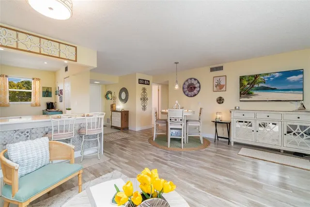 a living room with furniture a flat screen tv and kitchen view