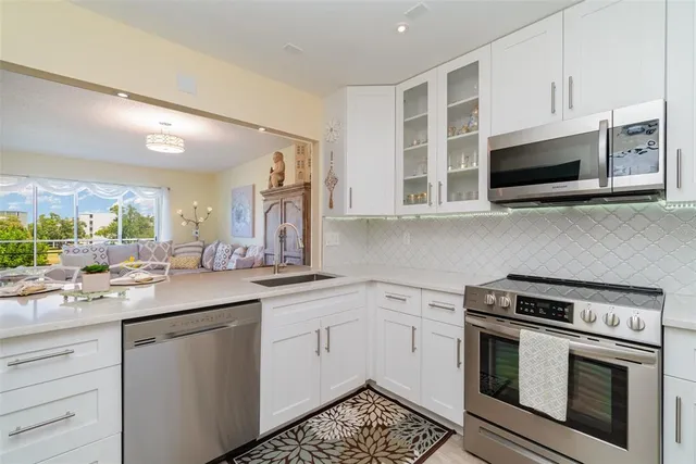 a kitchen with stainless steel appliances granite countertop a stove a sink and a microwave