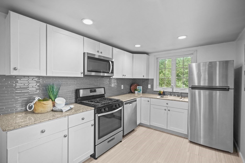 1122 Wood Street Fall River, MA 02721 - Photo 16 of 39 a kitchen with appliances a sink a window and cabinets