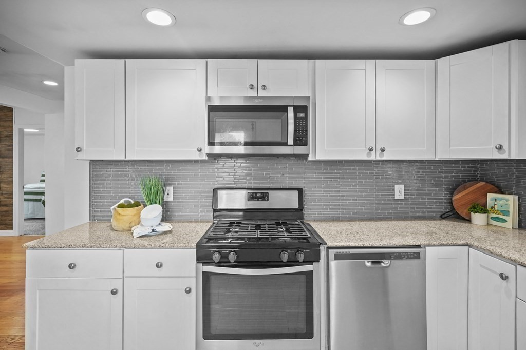 1122 Wood Street Fall River, MA 02721 - Photo 17 of 39 a kitchen with granite countertop white cabinets and stainless steel appliances