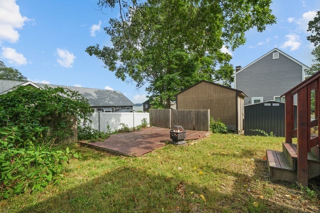 1122 Wood Street Fall River, MA 02721 - Photo 33 of 39 a backyard of a house with table and chairs under an umbrella
