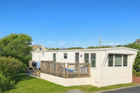 a view of house with yard and sitting area