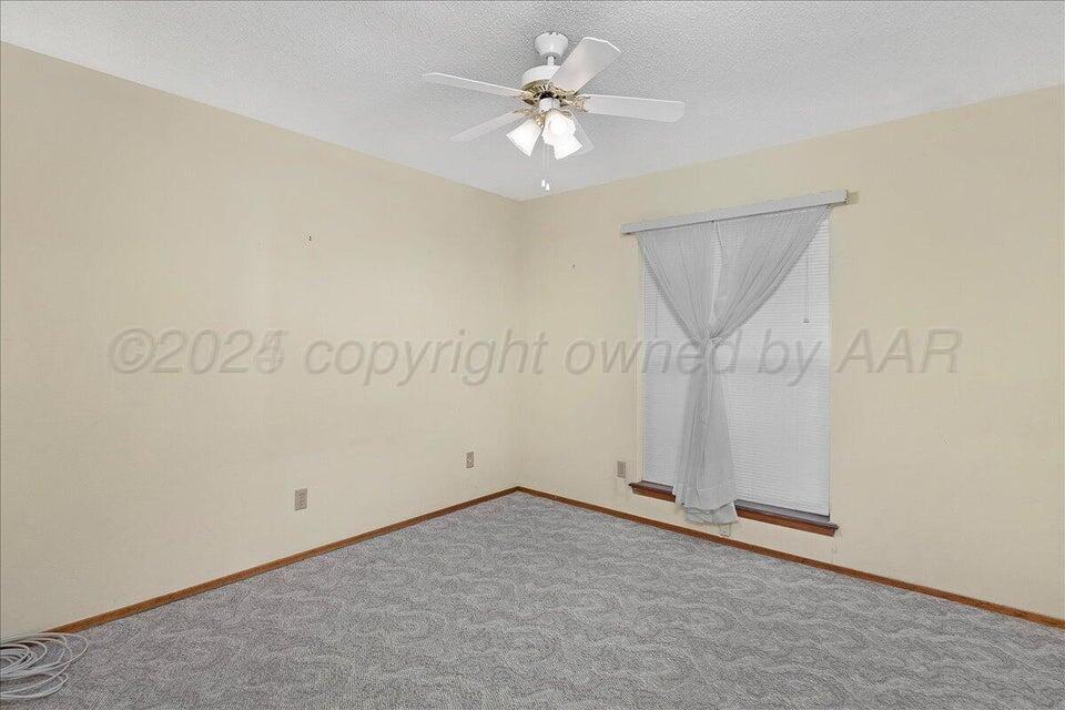 3900 Ozark Trail Amarillo, TX 79109 - Photo 10 of 15 an empty room with chandelier fan and windows