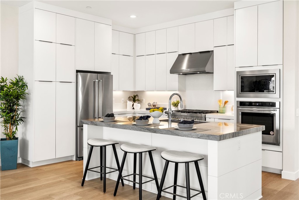 130 Pin Lane Lake Forest, CA 92630 - Photo 40 of 70 a kitchen with stainless steel appliances a dining table chairs refrigerator and microwave