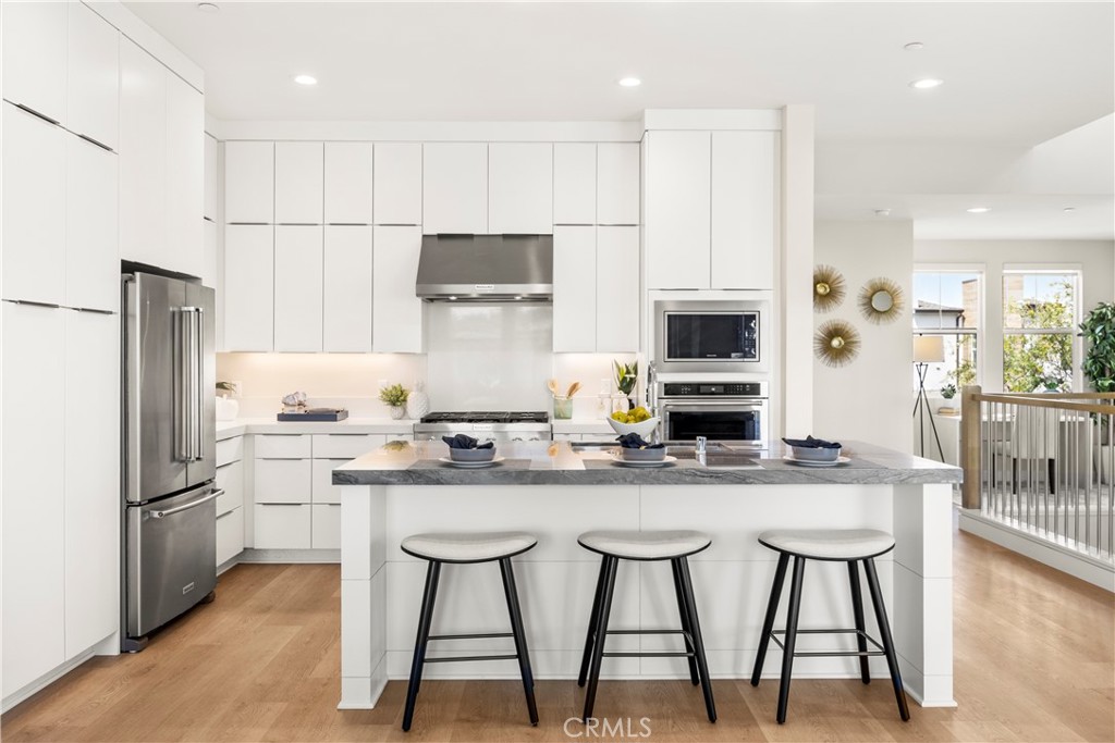 130 Pin Lane Lake Forest, CA 92630 - Photo 43 of 70 a kitchen with stainless steel appliances granite countertop a stove a sink a microwave a refrigerator and white cabinets