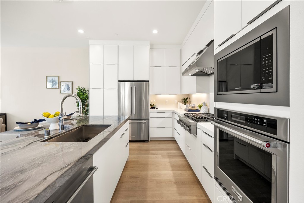 130 Pin Lane Lake Forest, CA 92630 - Photo 44 of 70 a kitchen with kitchen island granite countertop a stove and a sink